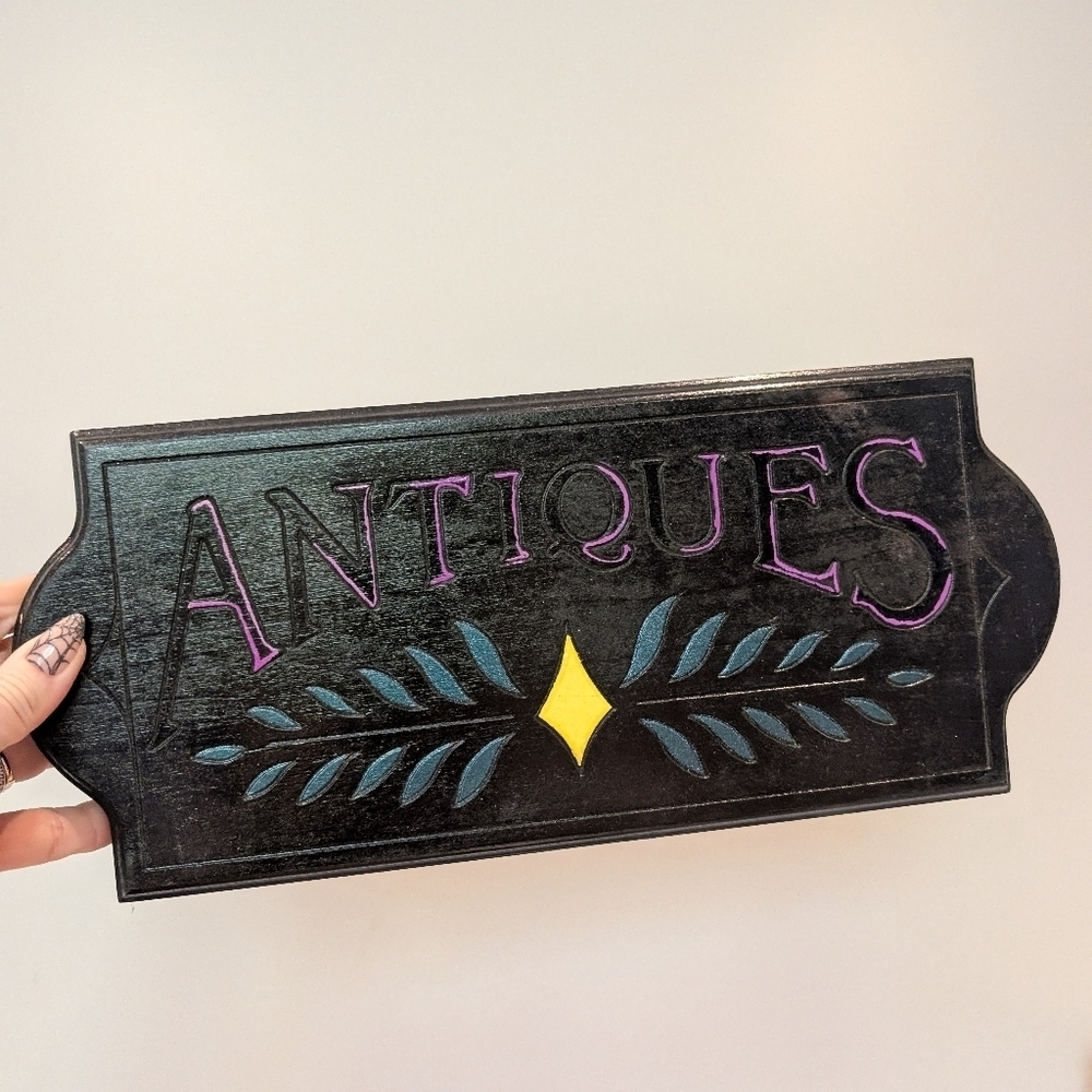 Black and Purple Antiques Sign